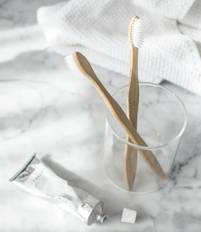 toothbrushes and toothpaste on white background